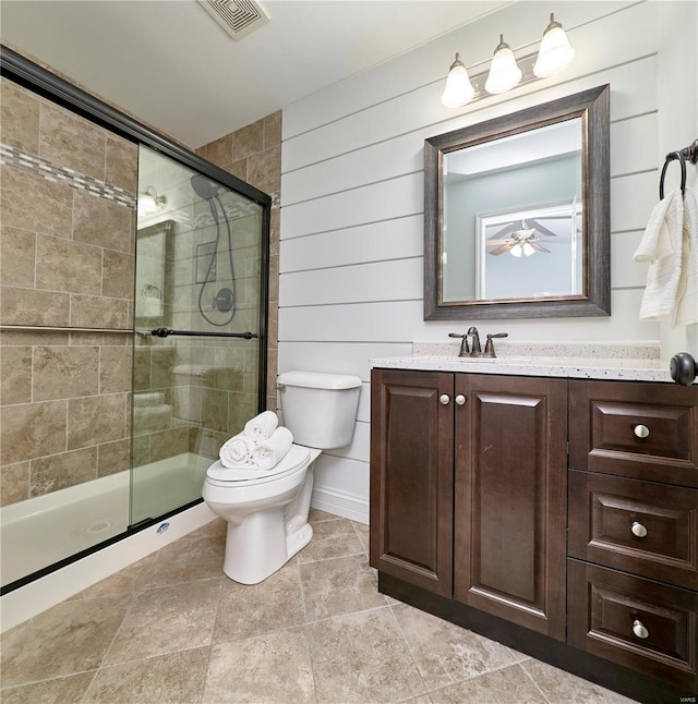 bathroom with vanity, visible vents, a stall shower, ceiling fan, and toilet