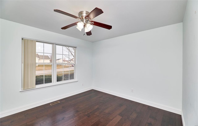 unfurnished room with dark wood finished floors, visible vents, baseboards, and ceiling fan