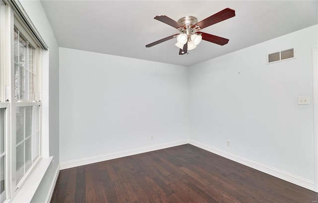 unfurnished room featuring visible vents, baseboards, ceiling fan, and dark wood-style flooring