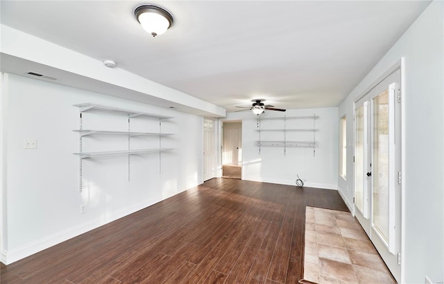 unfurnished living room featuring wood finished floors, a ceiling fan, visible vents, and baseboards