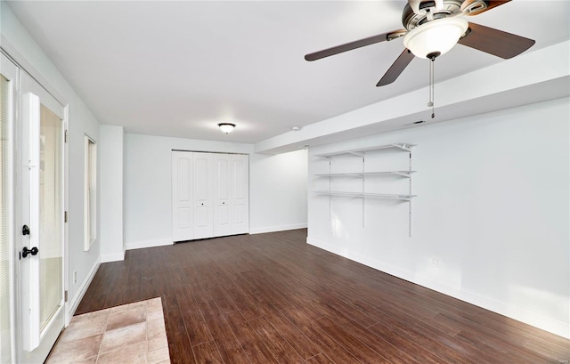 interior space featuring baseboards, wood finished floors, and a ceiling fan