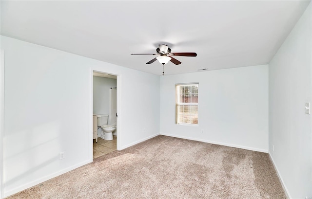 carpeted spare room featuring visible vents, baseboards, and ceiling fan