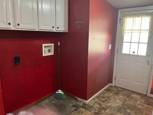 clothes washing area with baseboards, hookup for a washing machine, cabinet space, electric dryer hookup, and a textured ceiling