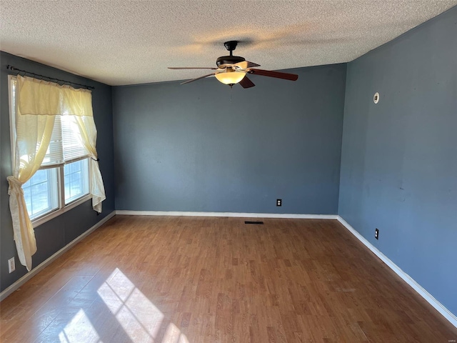 unfurnished room featuring baseboards, a textured ceiling, and wood finished floors