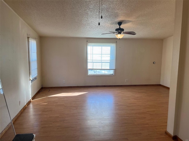 unfurnished room featuring a textured ceiling, baseboards, light wood-style floors, and a ceiling fan