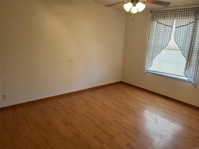 unfurnished room with ceiling fan, baseboards, and light wood-style floors