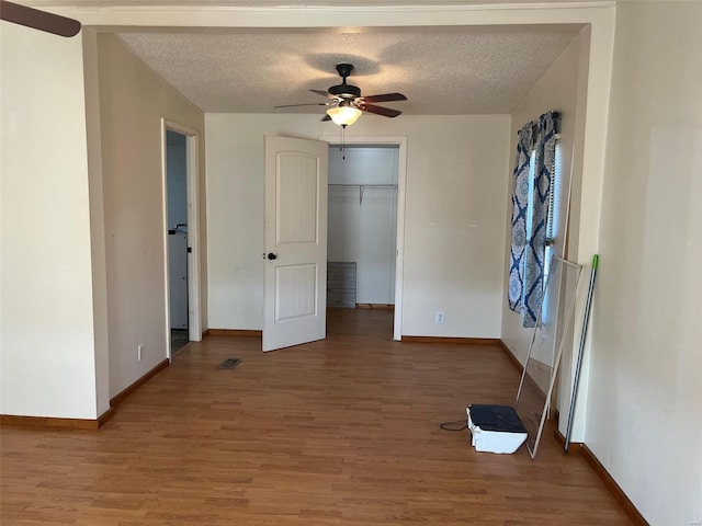 unfurnished bedroom featuring baseboards, a textured ceiling, and light wood finished floors