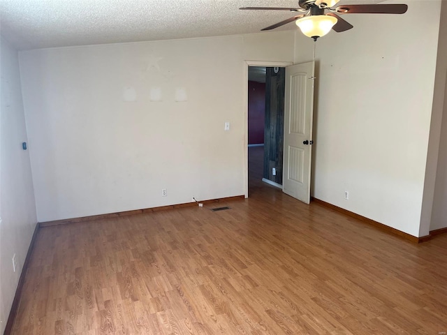 empty room with visible vents, light wood-style floors, and a textured ceiling