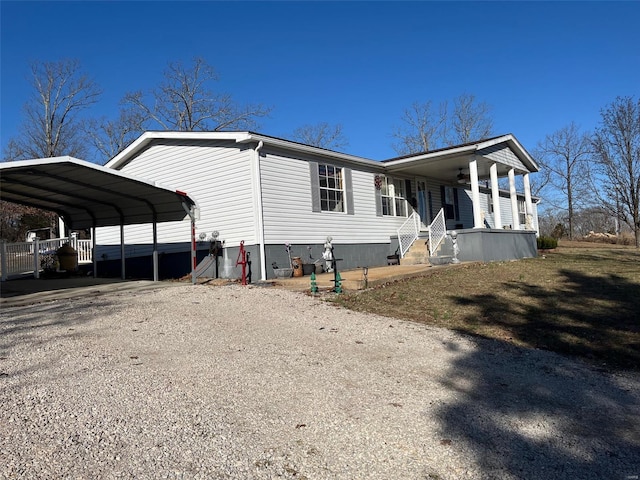 view of front facade featuring a carport, covered porch, and gravel driveway