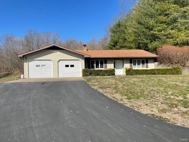 ranch-style home with aphalt driveway, a front yard, a chimney, and an attached garage