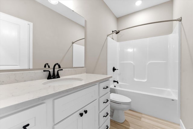 bathroom featuring vanity, toilet, shower / bathing tub combination, and wood finished floors