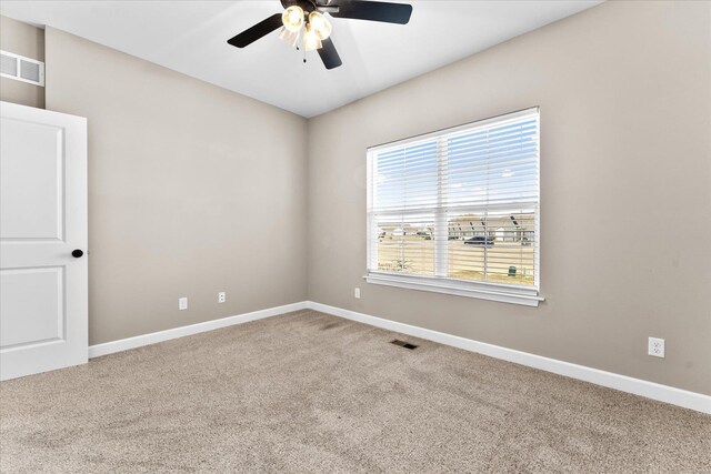 carpeted spare room with a ceiling fan, baseboards, and visible vents