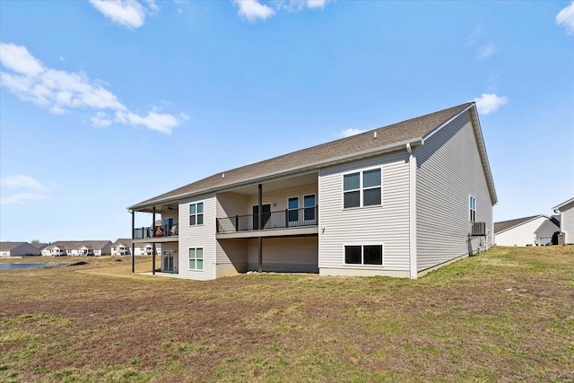 back of house featuring a balcony and a lawn