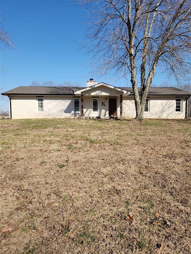 rear view of property featuring a lawn