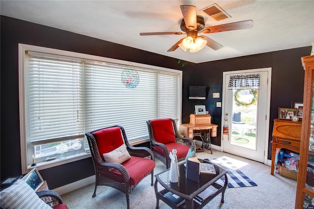 sitting room with visible vents, carpet, baseboards, and ceiling fan