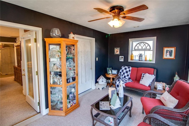 living area with carpet flooring, visible vents, and ceiling fan