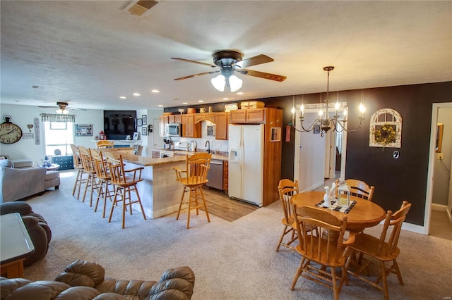 dining area with visible vents, recessed lighting, a textured ceiling, light carpet, and ceiling fan with notable chandelier