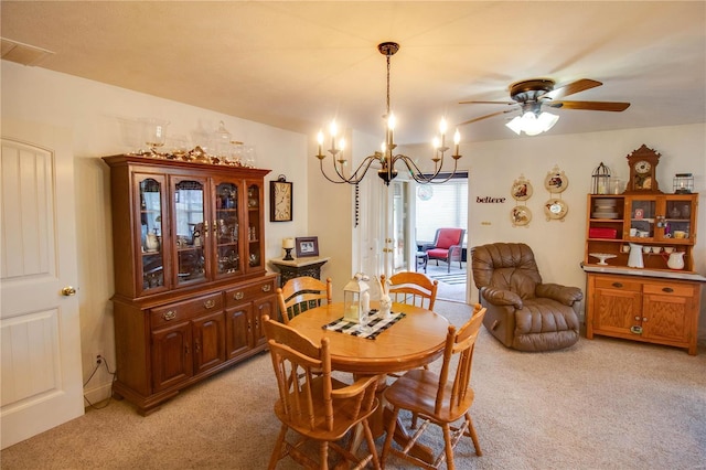 dining room featuring light carpet and ceiling fan with notable chandelier