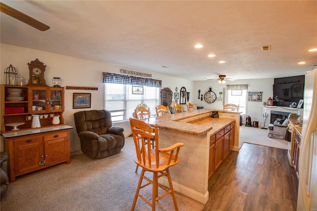 kitchen with a breakfast bar area, recessed lighting, open floor plan, and ceiling fan