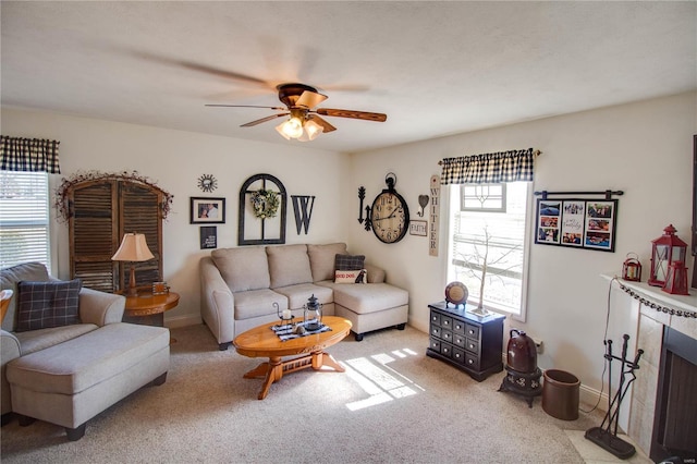 living area with baseboards, carpet, ceiling fan, and a fireplace with flush hearth