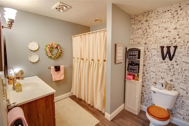 full bath with toilet, wood finished floors, a shower with shower curtain, baseboards, and vanity