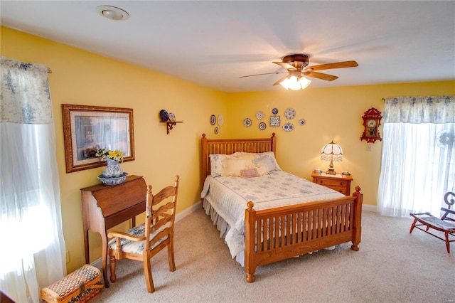 bedroom featuring baseboards, light carpet, and a ceiling fan