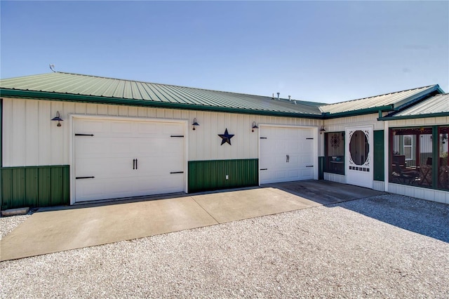 exterior space with a garage, driveway, and metal roof