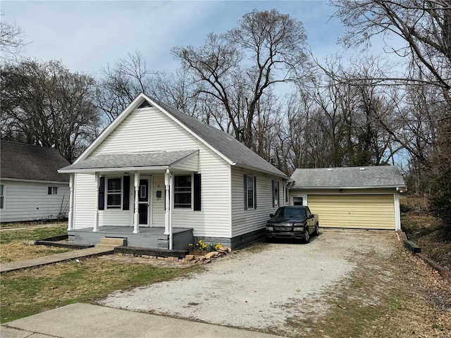 bungalow-style house with a porch, an outbuilding, and roof with shingles