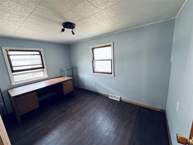 unfurnished bedroom with dark wood-type flooring, baseboards, and visible vents