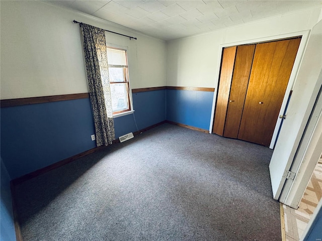 unfurnished bedroom with visible vents, a closet, and carpet flooring