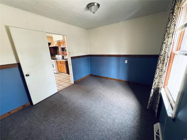 unfurnished room with baseboards, visible vents, and light carpet