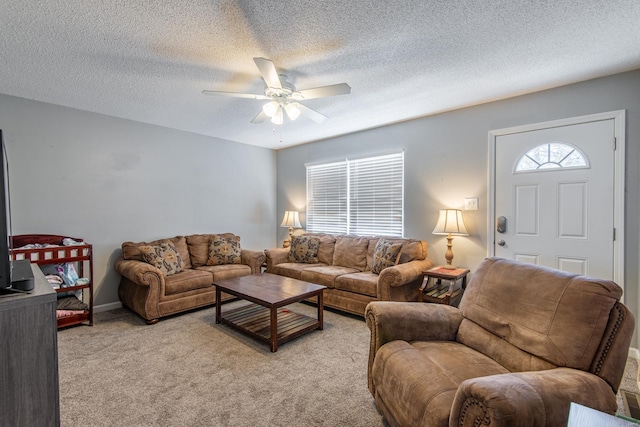 living room with ceiling fan, a textured ceiling, and light carpet