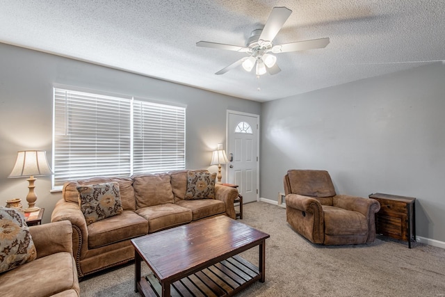 living room featuring baseboards, carpet, ceiling fan, and a textured ceiling