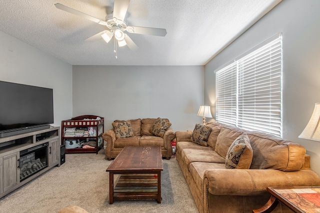 living area featuring light carpet, a textured ceiling, and ceiling fan