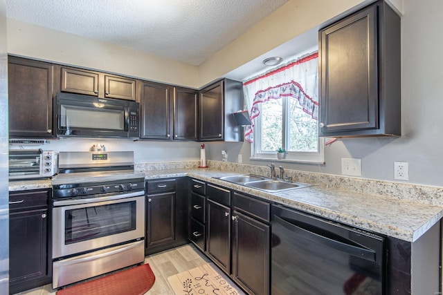 kitchen with black appliances, a sink, a textured ceiling, a toaster, and light countertops