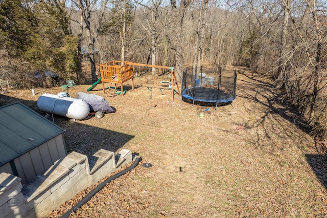 view of yard with a playground and a trampoline