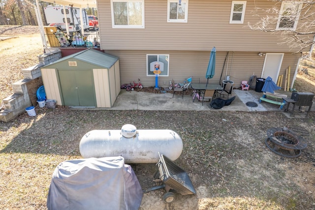 back of property with an outbuilding, a shed, and a patio