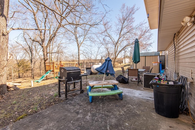 view of yard featuring outdoor dining space, cooling unit, a shed, an outdoor structure, and a playground