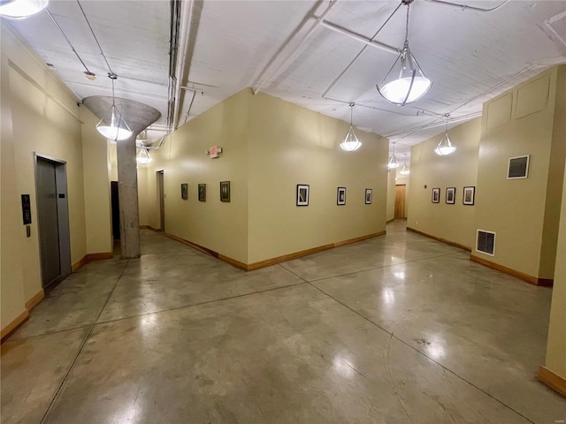 garage featuring elevator, visible vents, and baseboards