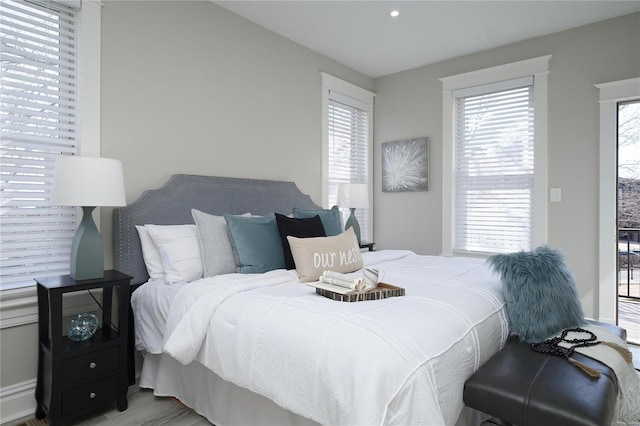 bedroom with multiple windows and wood finished floors