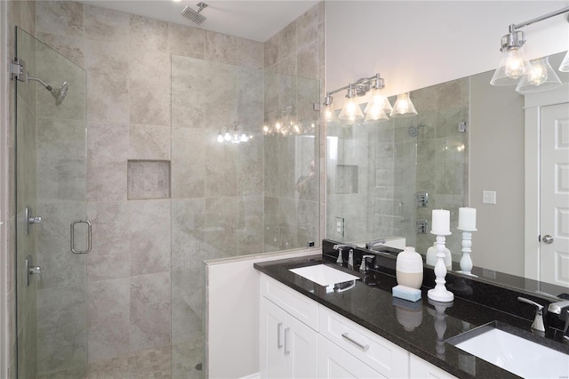 full bathroom featuring double vanity, visible vents, a stall shower, and a sink