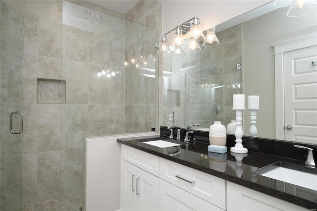 full bathroom with double vanity, a stall shower, and a sink