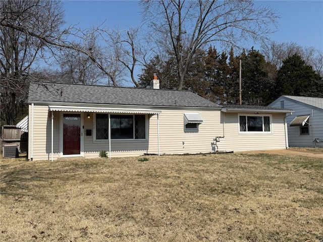 single story home featuring a chimney, a front lawn, and a shingled roof