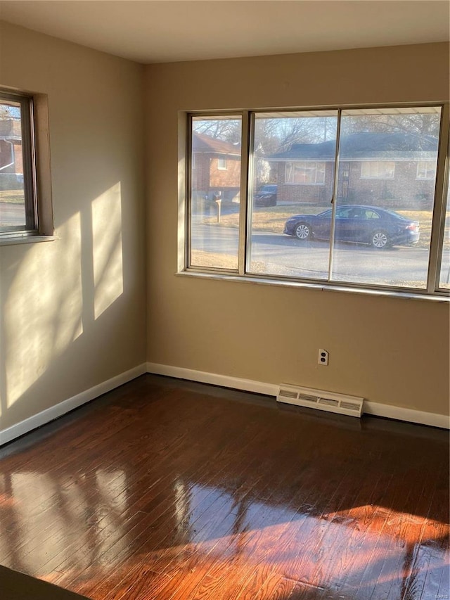 empty room featuring a wealth of natural light, visible vents, and baseboards