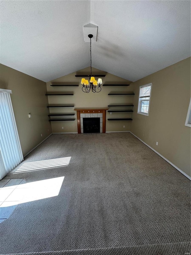 unfurnished living room featuring carpet, vaulted ceiling, a fireplace, a notable chandelier, and a textured ceiling