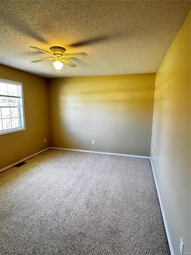 unfurnished room featuring a textured ceiling, visible vents, carpet floors, and ceiling fan