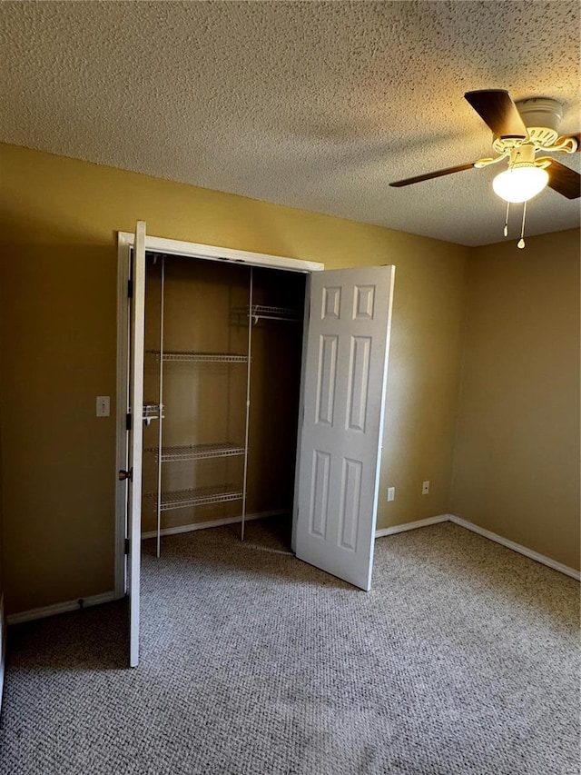 unfurnished bedroom with a ceiling fan, baseboards, carpet floors, a closet, and a textured ceiling