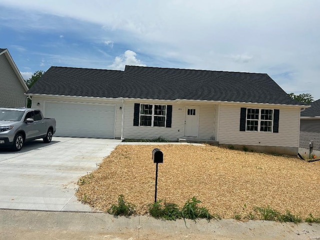 single story home with concrete driveway and an attached garage