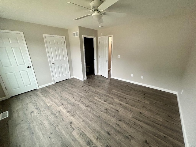 unfurnished bedroom featuring visible vents, a ceiling fan, baseboards, and wood finished floors