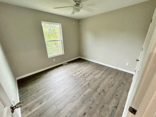 empty room with ceiling fan, baseboards, and wood finished floors